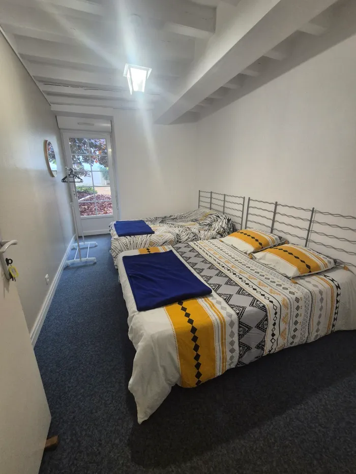 Une chambre cosy aux touches de jaune et de bleu, lits faits