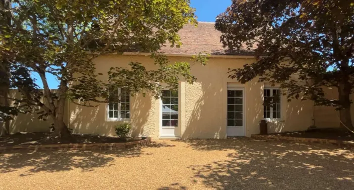 La façade du bâtiment qui abrite le grand dortoir, sur sa cour gravillonnée ombragée