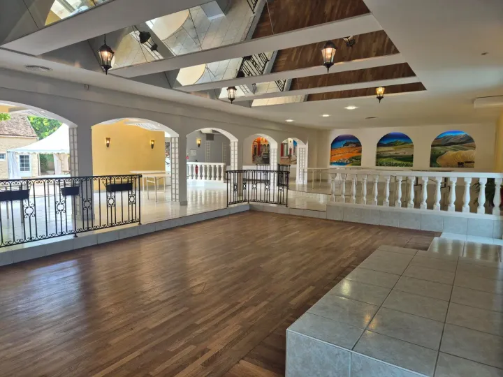 La grande salle de réception de 300 m² du Domaine Le Grand Chêne, avec sa baie vitrée sur le parc