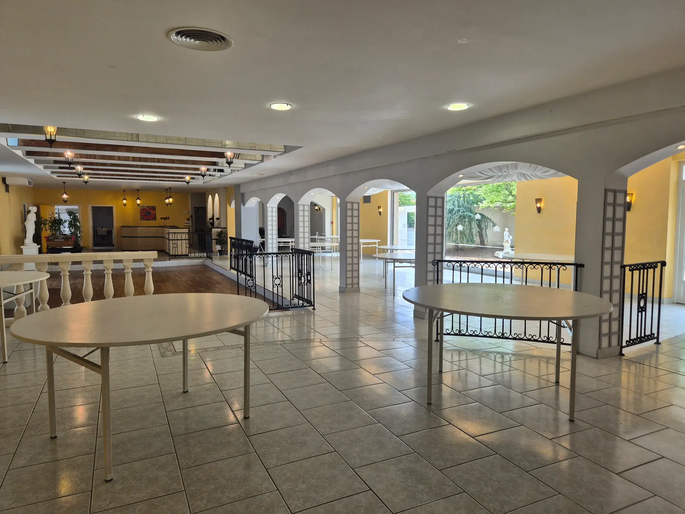 Grande salle du Domaine Le Grand Chêne dressée en tables rondes pour un dîner de mariage