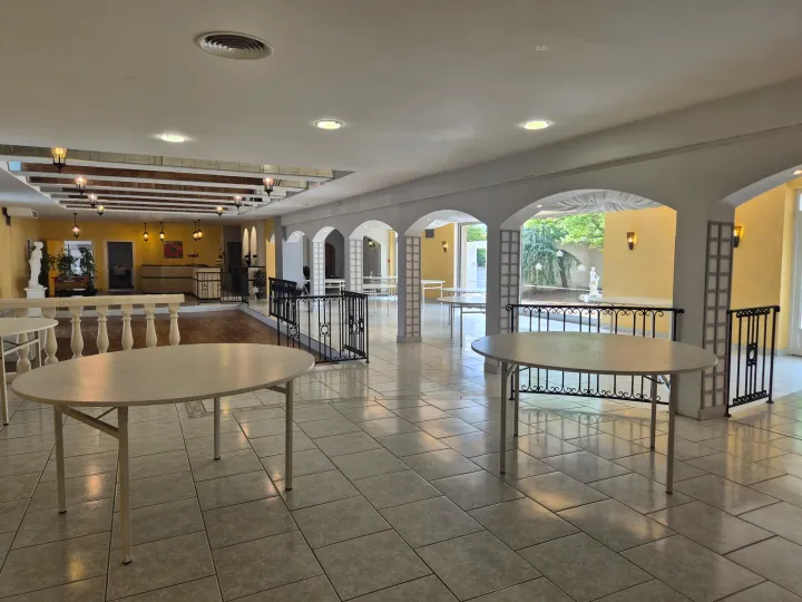 Grande salle du Domaine Le Grand Chêne dressée en tables rondes pour un dîner de mariage